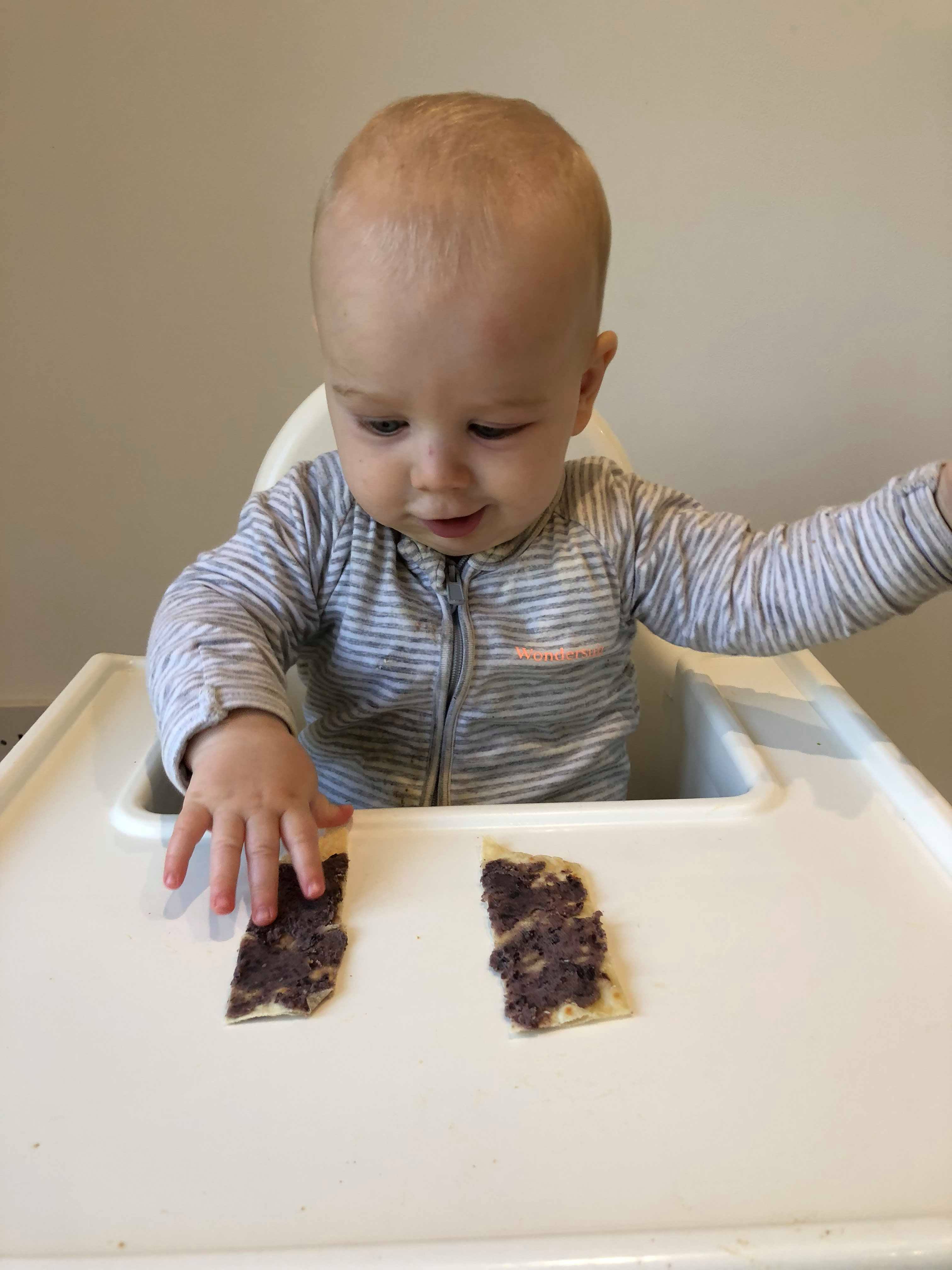 Lewis 6 months old with black bean paste on flat bread